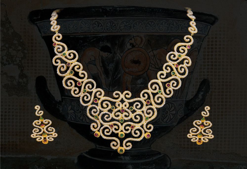 Collier ed orecchini in oro realizzati interamente a mano in stile bizantino. Sono state infilate micro perline scaramazze e incastonate pietre di rubini e smeraldi.